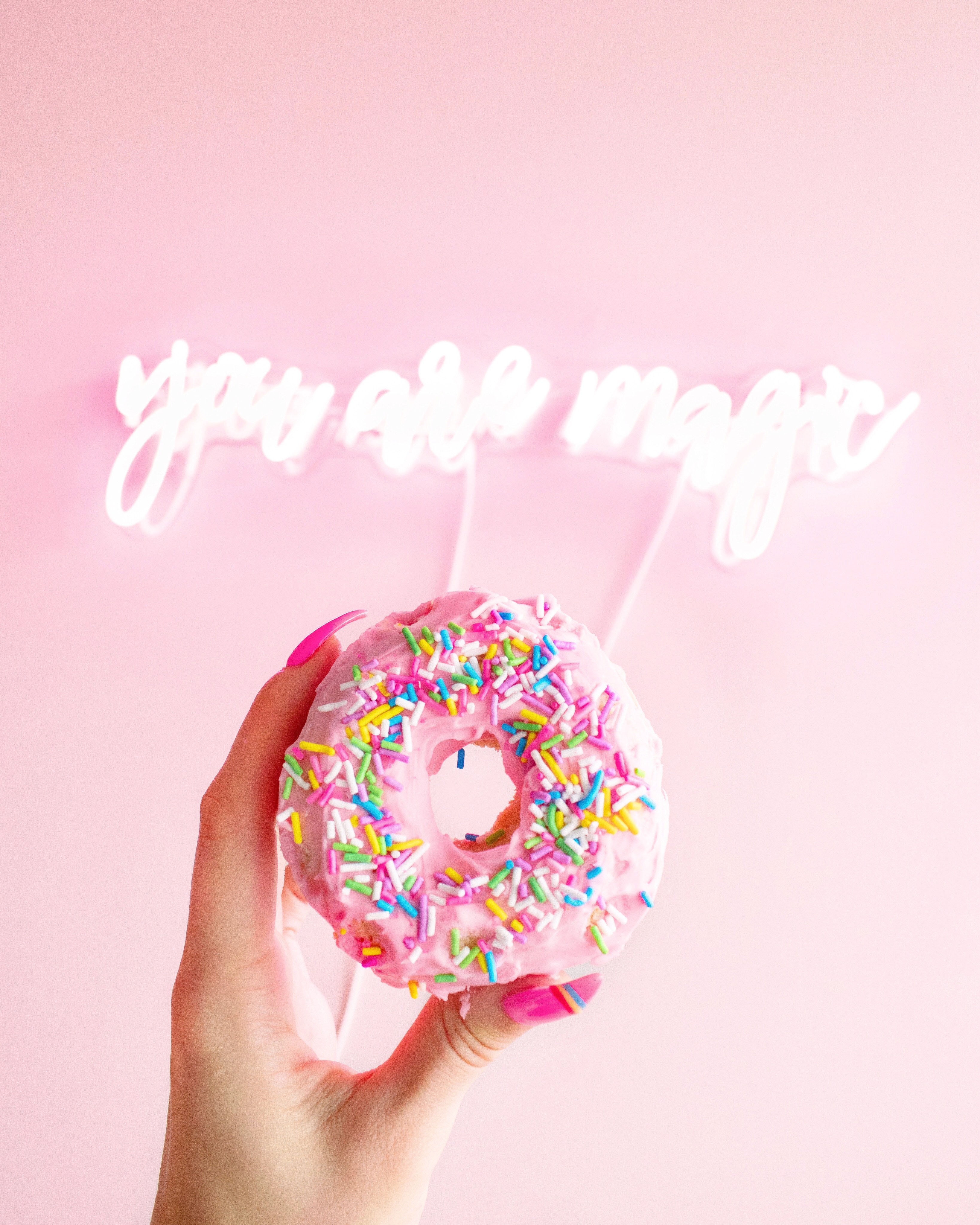 You are magic sign with a woman holding up a donut