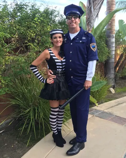 Man and woman dressed as a prisoner and cop for Halloween