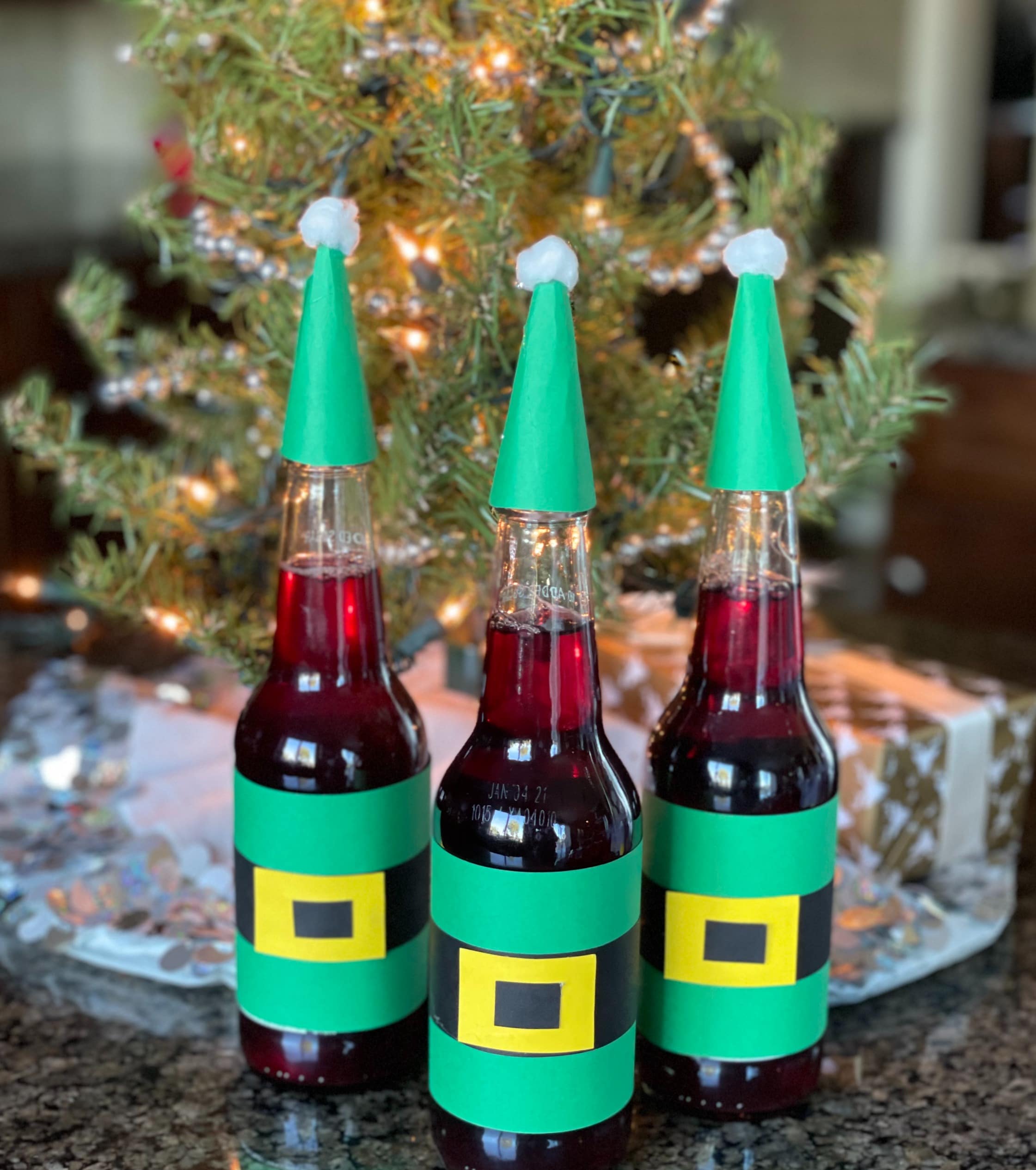 Glass soda bottles decorated in elf costumes