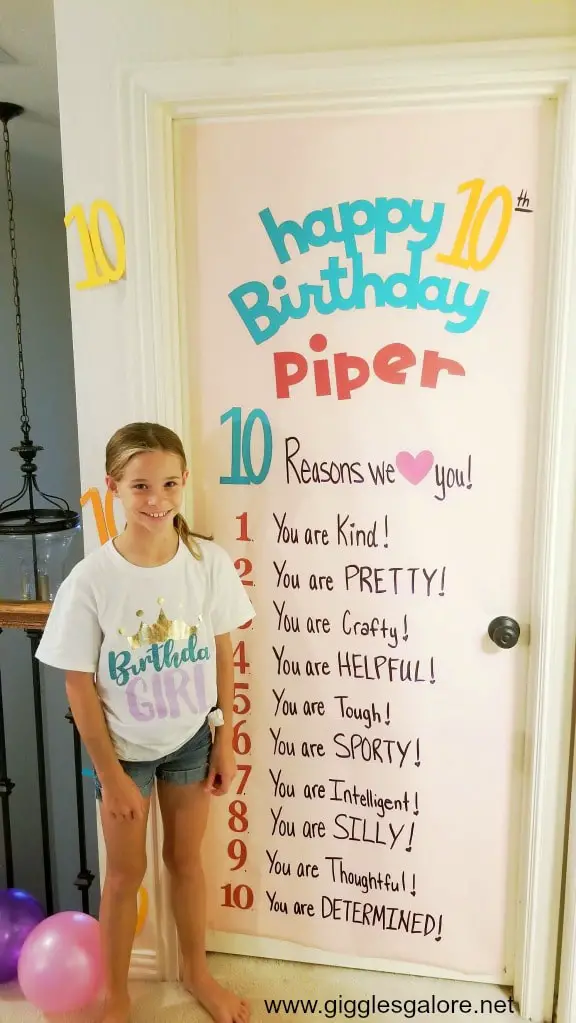Little girl standing in front of birthday door