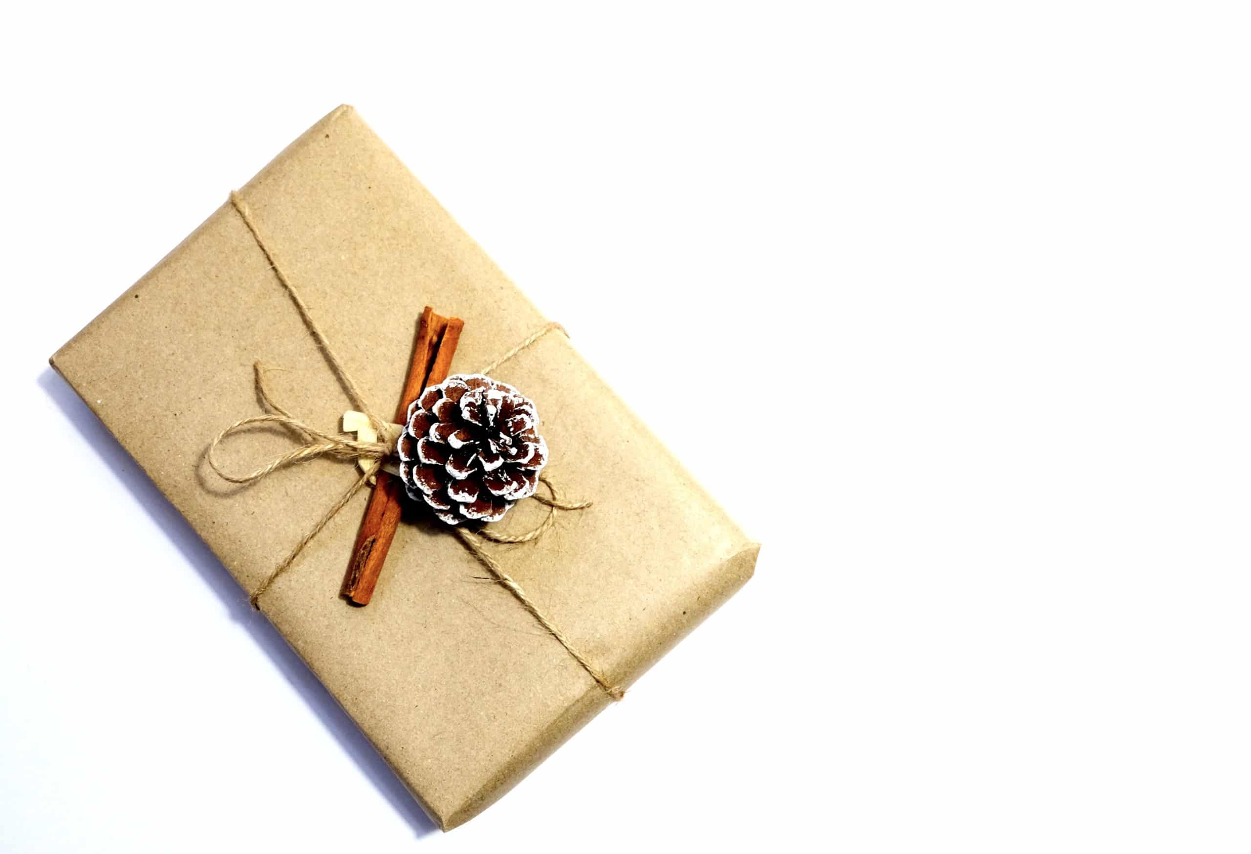 Gift wrapped in brown paper with a pinecone