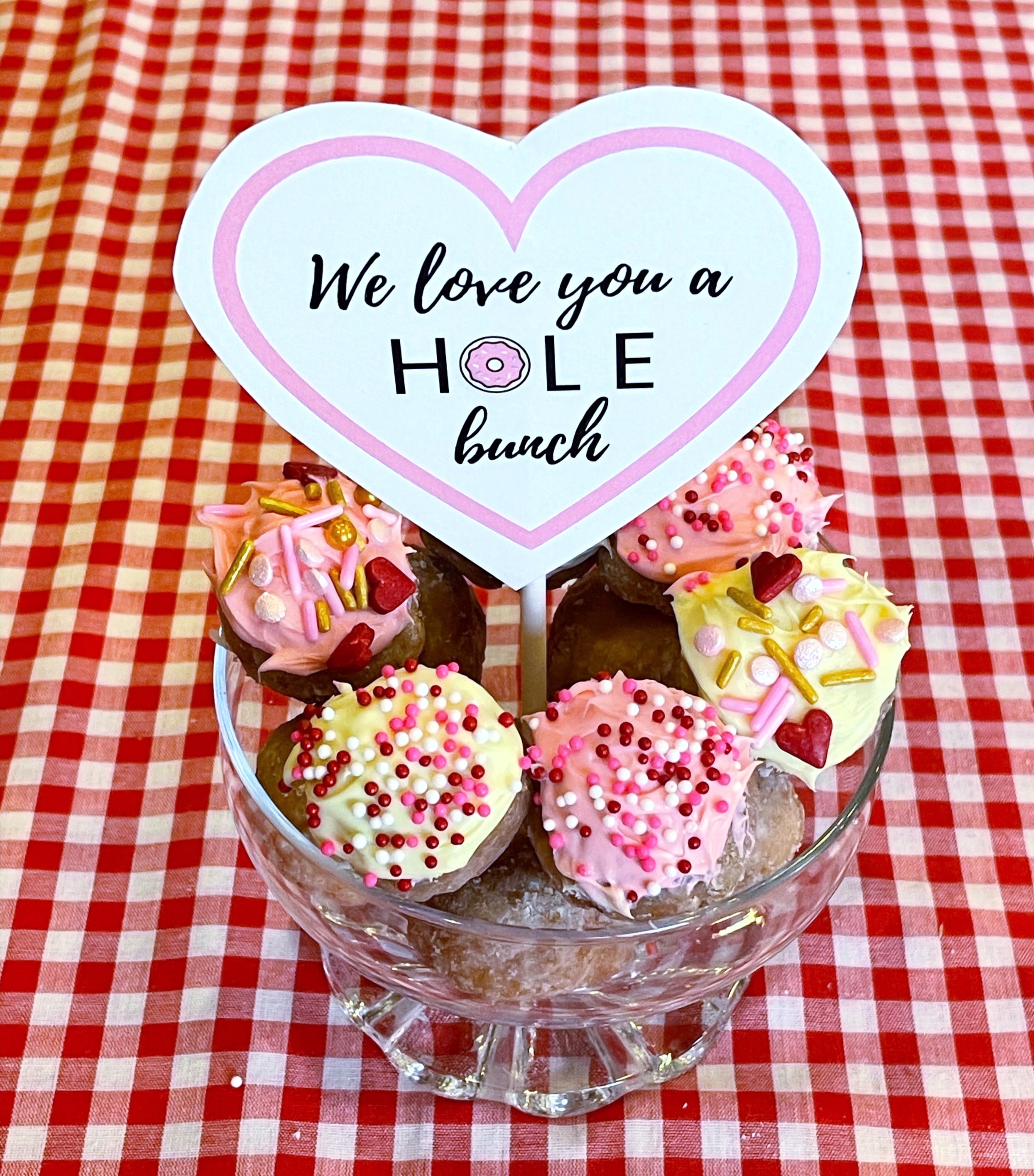 Donut holes with icing and sprinkles and Valentine's Day Sign