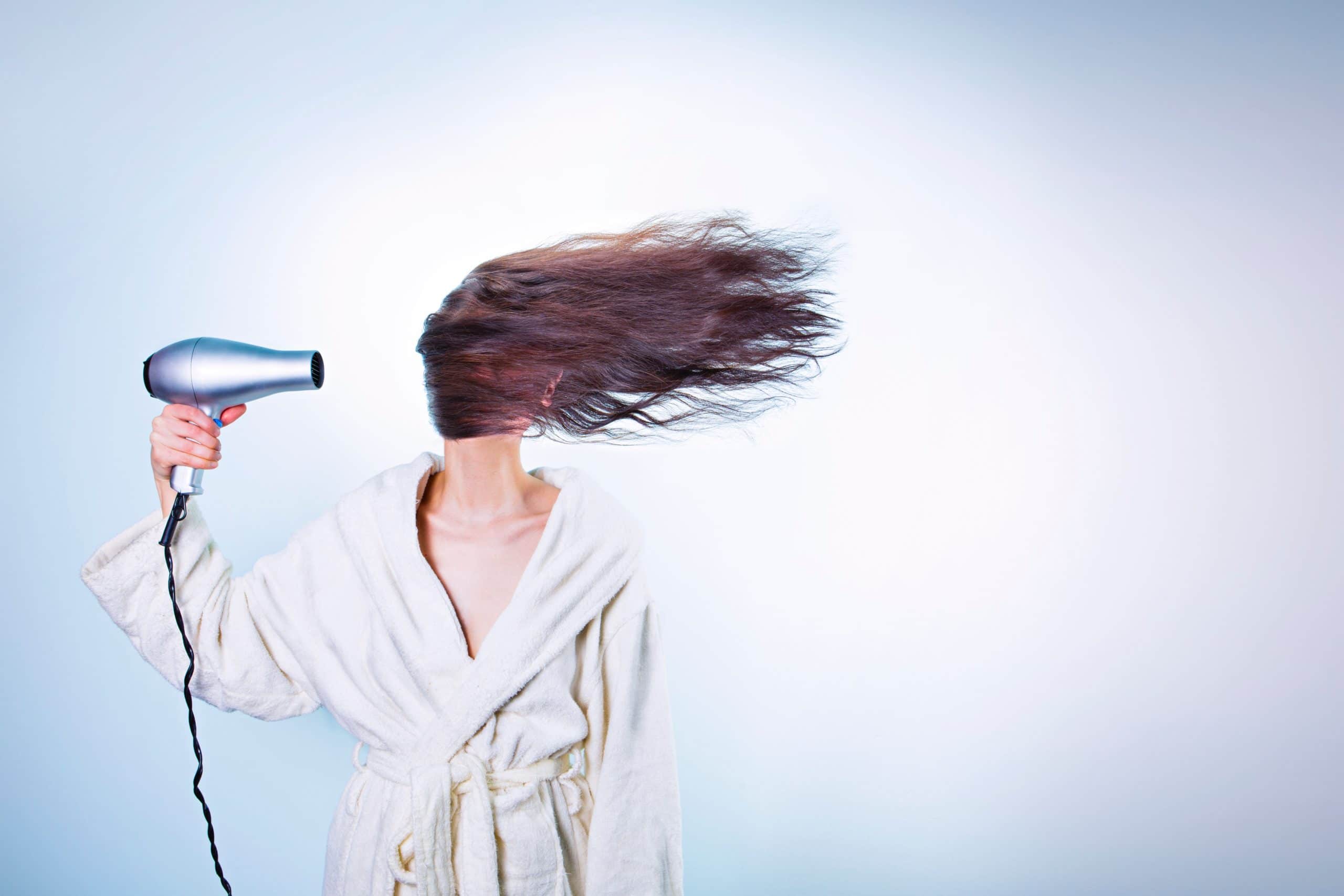 Woman blowing her hair dry in her face