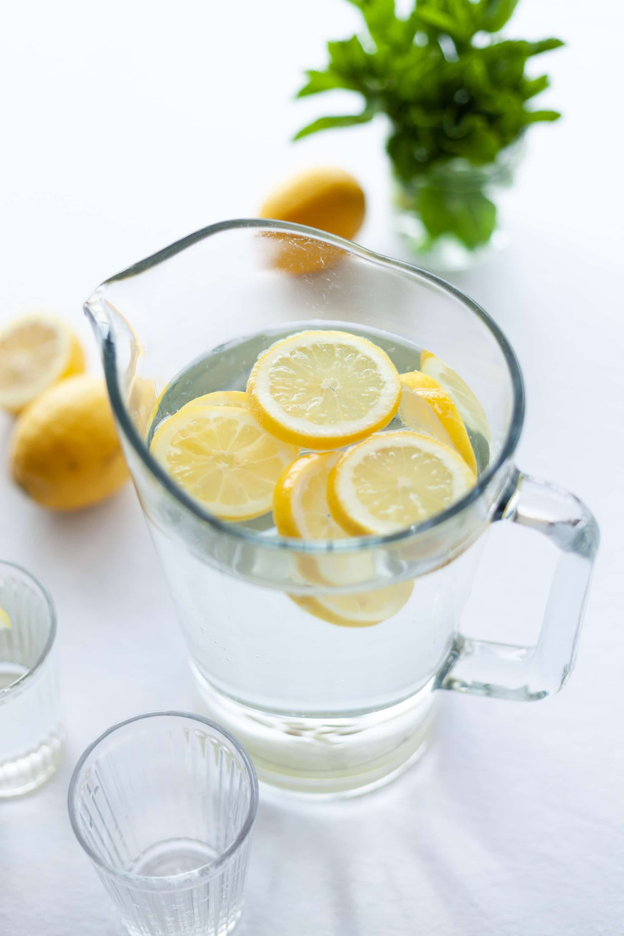 Glass pitcher filled with lemon water