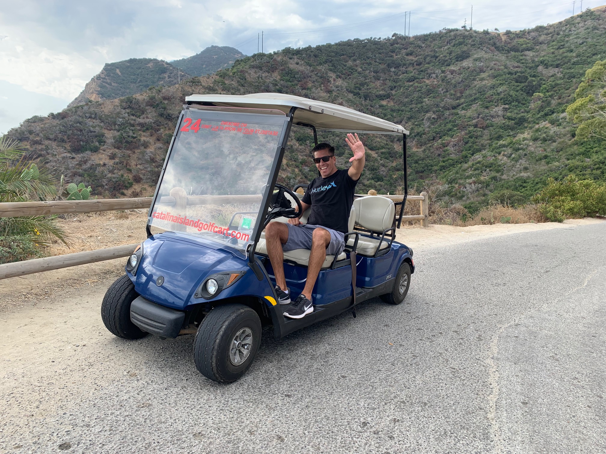 Man waving from a golf cart in Catalina Island