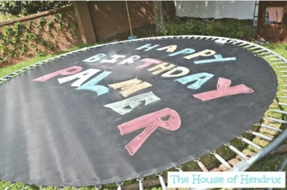 Chalk happy birthday sign on a trampoline