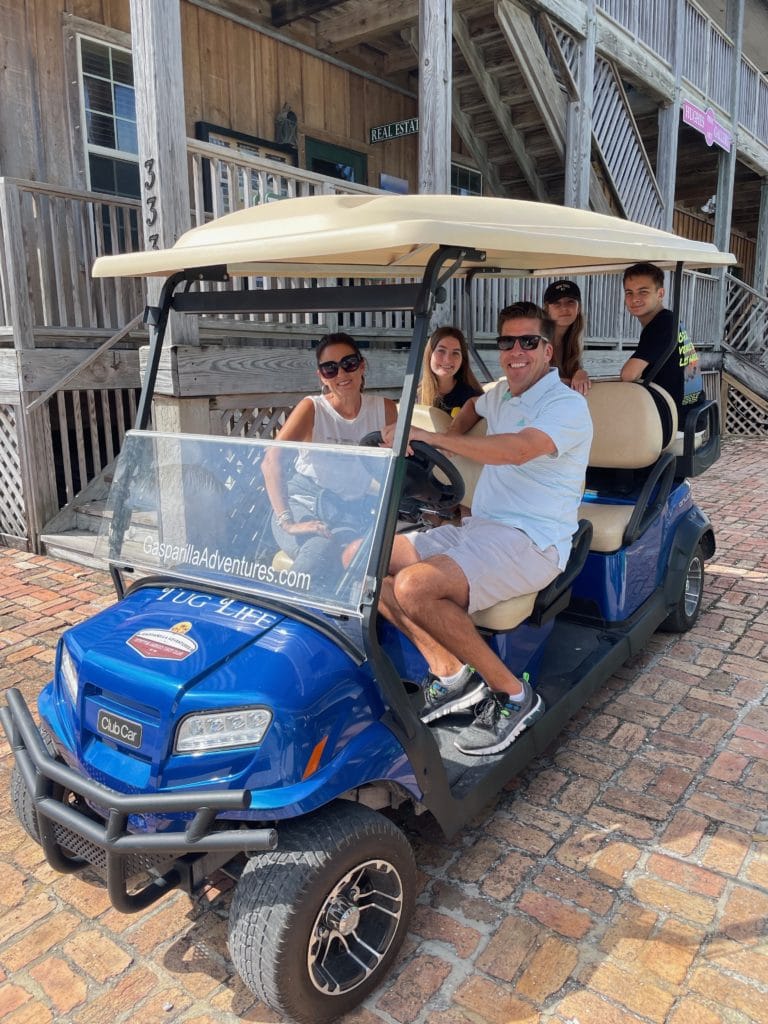 Family in a large blue golf cart