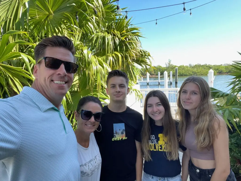 A family smiling for a water front selfie picture