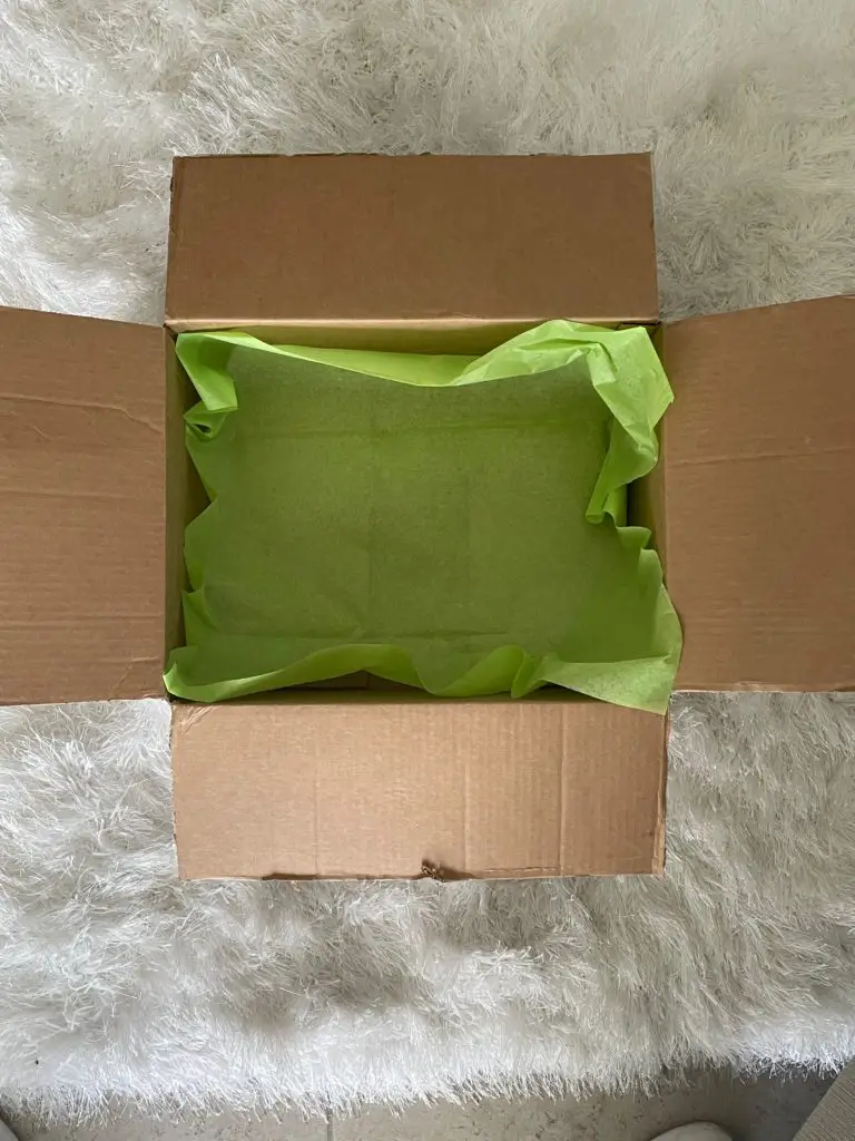 cardboard box with green tissue paper inside
